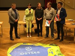 Bürgermeisterin Marietta Tzschoppe (2.v.l.), die Fachbereichsleiterin Stadtentwicklung Doreen Mohaupt sowie Ostseemanager Stefan Korb (l.) übergaben einen Ostsee-Teppich an Burkhard Schöps, Vorsitzender des Ostsee-Sportvereins, und Dennis Kettlitz (r.), Vorsitzender des Ostsee-Fördervereins.